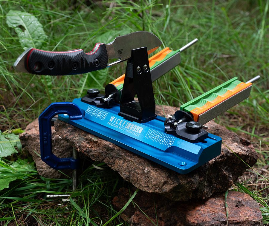 The Wicked Edge GO WE60 precision sharpener clamped to a rock outdoors